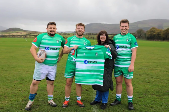 Joanne Pontee presenting the new kit to three PDMS Nomads rugby players