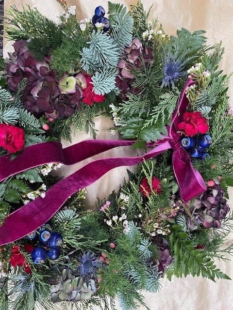 A festive wreath complete with coloured berries, flowers and ribbons.