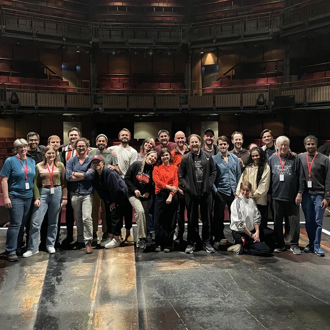 Members of the Twelfth Night company and team standing on the stage in the Royal Shakespeare Theatre, looking out towards the seating.