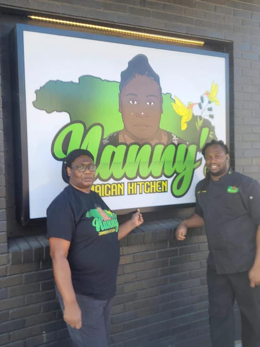 Owners of Nanny's Jamaican Kitchen, standing outside near their logo