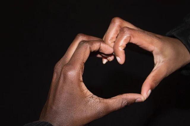 Two different hand’s coming together to form the shape of a heart