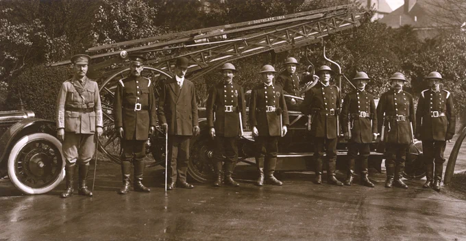 Crew from Southgate District Council Fire Brigade during the First World War. The crew are stood in front of their fire engine wearing the standard woollen tunics, supplemented with military helmets