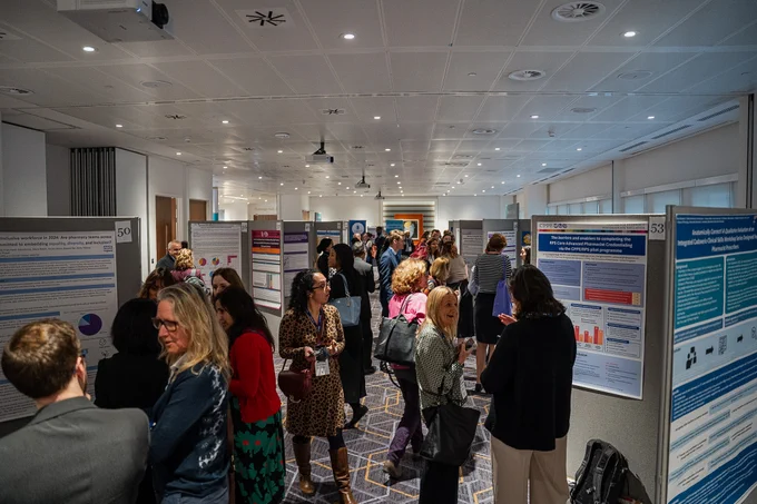 Photo of delegates at the RPS Conference talking and looking at the research posters on display.