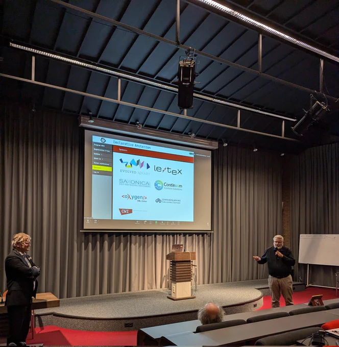 Gerrit Imsieke is holding a microphone in front of the audience.