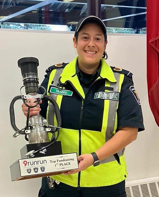 Paramedic Marina Tannis holding the fundraising trophy.