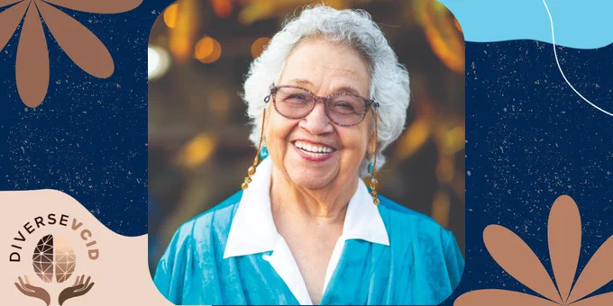 At the center is a photo of an older woman of color (race/ethnicity speculatively mixed heritage, Hispanic, Black, other) with medium-length wavy white hair, a great big smile, happy eyes, and wearing glasses with a beaded necklace attachment on the temples which drapes down to a white shirt with a broad open collar and a turquoise silky jacket.

To the lower right corner, on a tan amorphic shape, you see two hands of slightly different shades of brown holding up a top view of a stylized brain design in shades of brown at the center, and the word "DiVERSEVCID" (DIVERSE is in dark lettering, VCID is in medium brown) arching above the curvature of a brain, which almost resembles a circular design when perceived with the hands. 

The overall background is in Navy blue with a white speckled background resembling stars at night, also with with amorphic floral patterns in various shades brown and an aqua amorphic shape in the upper right hand corner.