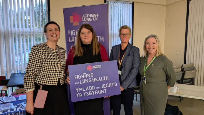 Sioned Williams MS standing with representatives of Asthma and Lung Heath and Swansea Bay University Health Board holding a bilingual board which reads Fighting for Lung Health