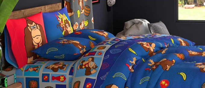 Franco Manufacturing Company's "Monkey Play" bedding on a full-size bed in the bedroom of a Donkey Kong fanatic. Donkey, Diddy, barrels, DK Barrels, bananas, banana bunches, and Star emblems make up the various patterns on the bedding.
