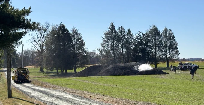 Firefighters squirting water on a pile of fertilizer