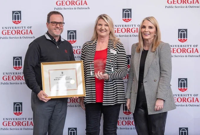 Emily Schattler of the Carl Vinson Institute of Government displays her PSO Award of Excellence with Jennifer Frum, vice president of Public Service and Outreach, and Rob Gordon, director of the Institute of Government.