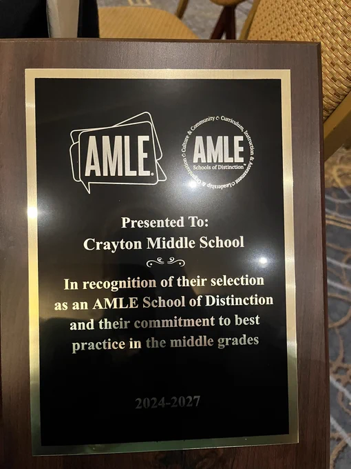 A plaque presented to Crayton Middle School, recognizing their selection as an AMLE School of Distinction from 2024 to 2027 for their commitment to best practices in middle-grade education.