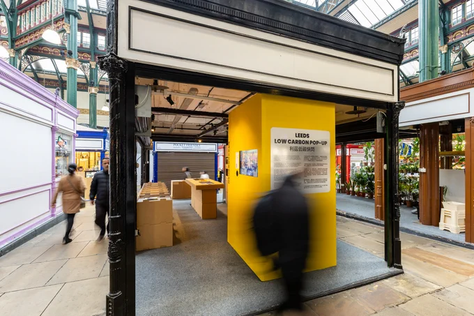 A blurry figure in front of the Leeds Low Carbon Pop up 
