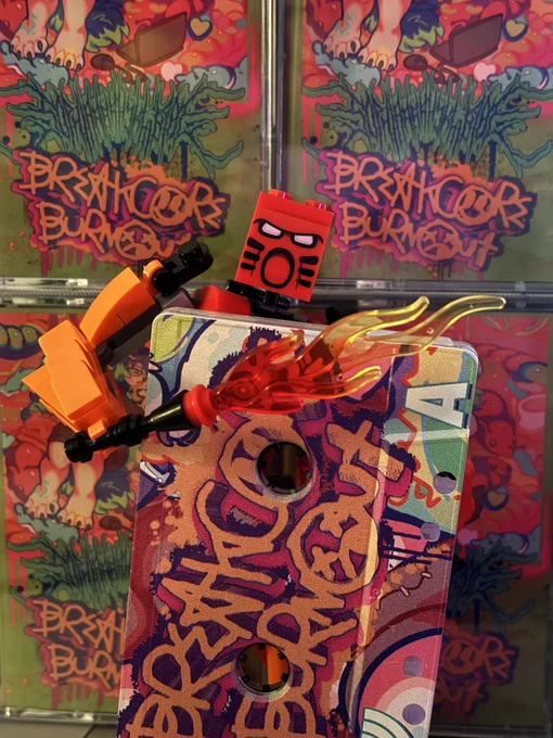 lego bionicle (tahu, the red one) holds a copy on tape. it is nearly bigger than him. he stands in front of a wall of cassette cases