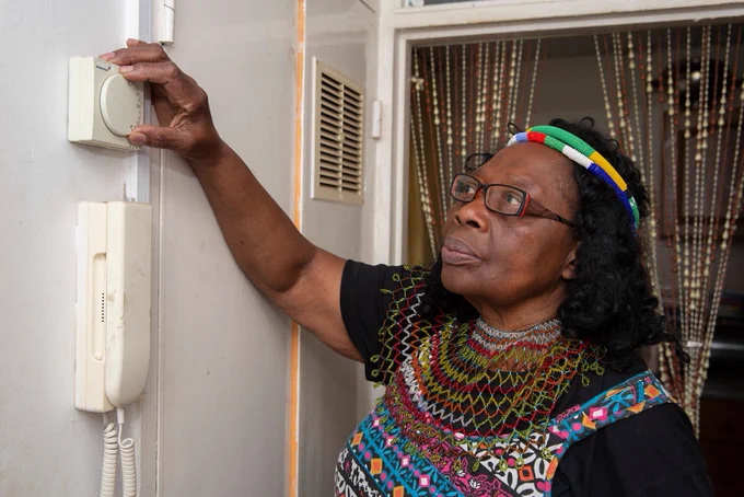 Older woman adjusting thermostat