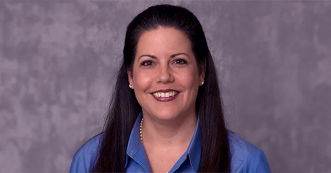 Photo of smiling female professor in blue blouse