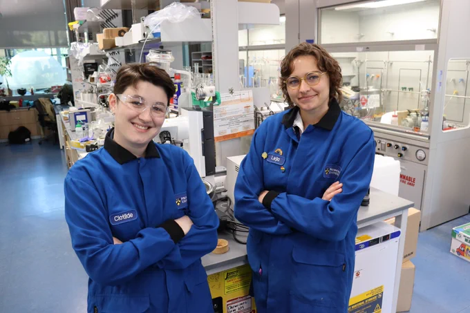 Full-color image of the two hosts of the podcast standing in one of the lab's at Princeton Chemistry. 