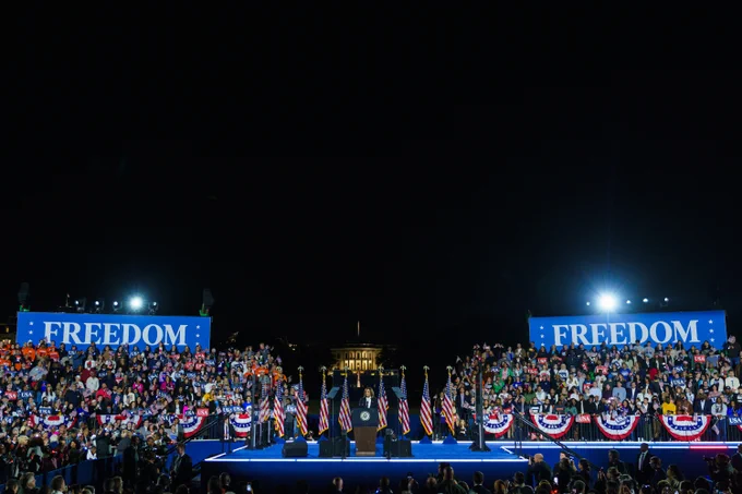 Vice President Kamala Harris delivering remarks at the Ellipse in Washington D.C. Behind her are supporting sitting on the stands and “FREEDOM” backdrops. 