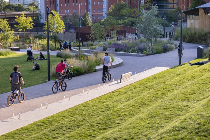 people in a sunny park, riding bicycles and sitting