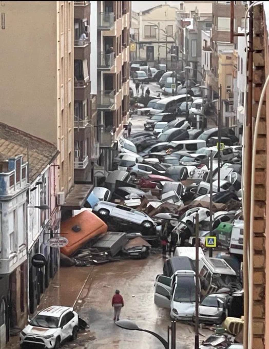 Smashed up cars piled on top of each other in the streets