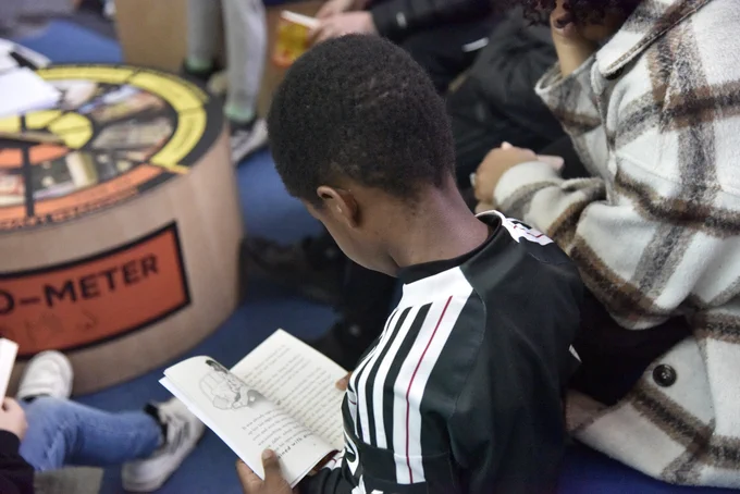 A young boy reading from a book.
