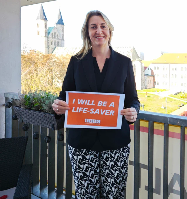 Alexandra Mehnert MEP holds up the orange and white banner for the I Will Be A Life-Saver campaign.  