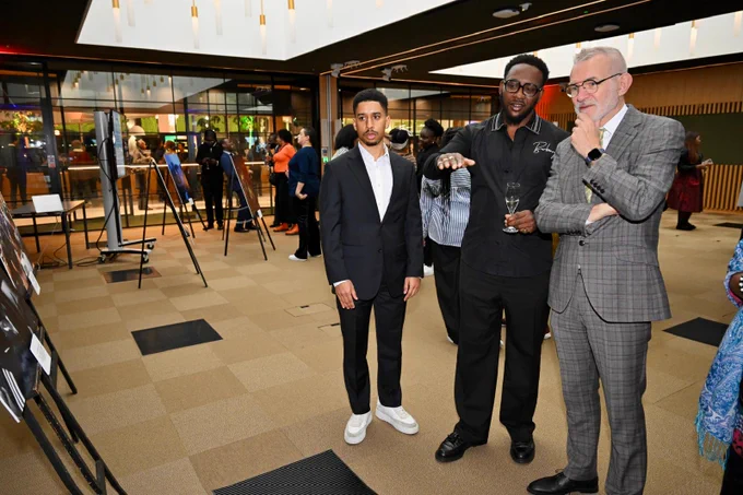 Three men looking at an exhibition