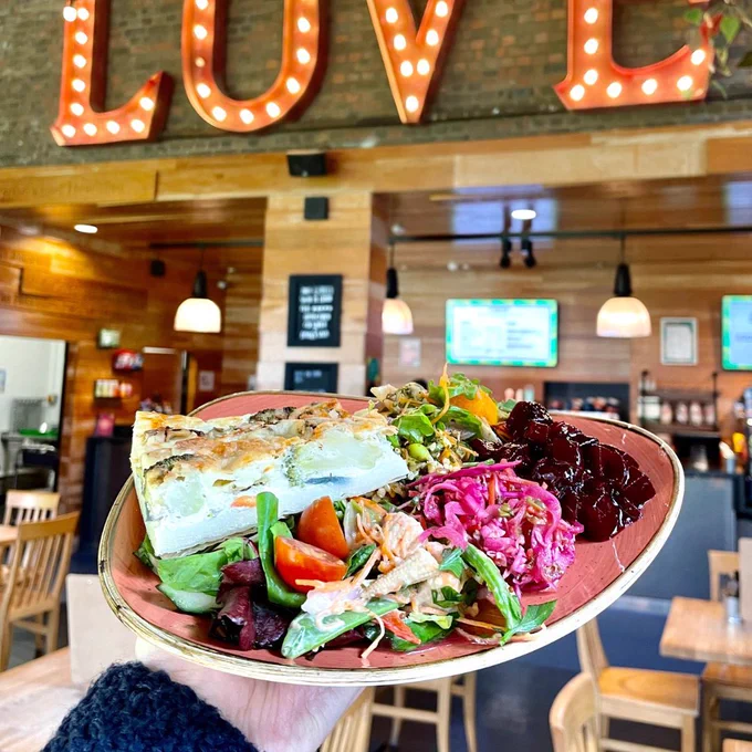A photo of a quiche and vibrant salads.