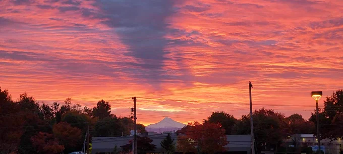 Orange sunrise over Mount Hood from the NWS Portland Office with a volcano shadow evident in the lack of orange coloring due to Mount Hood blocking the sunrise. 