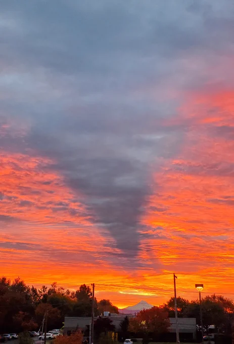 Orange sunrise over Mount Hood from the NWS Portland Office with a volcano shadow evident in the lack of orange coloring due to Mount Hood blocking the sunrise. 