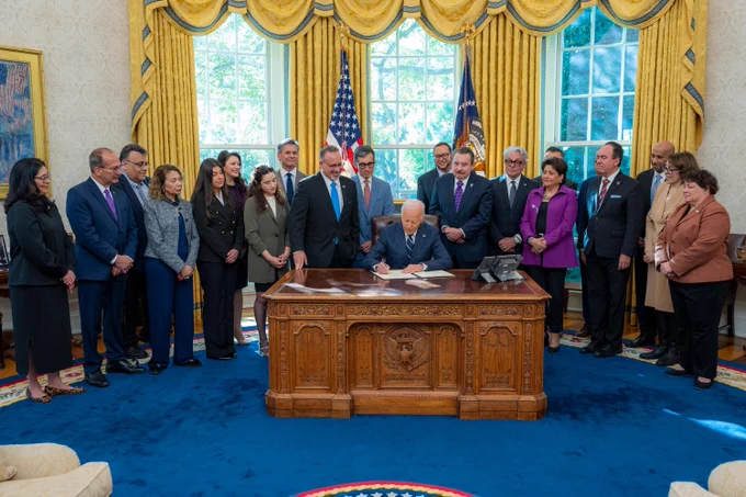 President Biden and others gather in the Oval Office to celebrate the first-ever commission and President’s Advisory Board for HSIs.