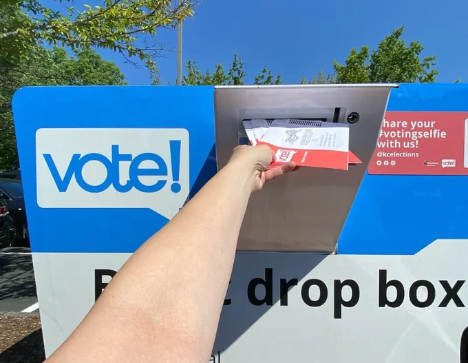 A person drops off a ballot at a King County Ballot Drop Box.