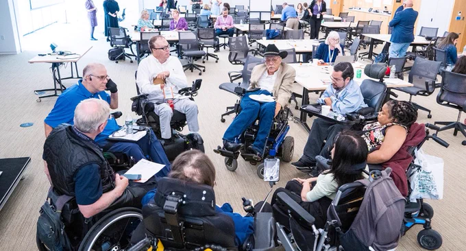 Image of all the wheelchair users at our 2024 Global Forum in a circle discussing areas of potential improvement for getting wheelchairs on planes.