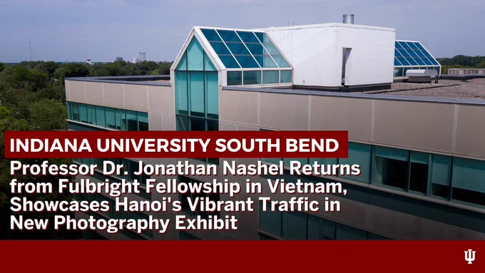 Indiana University South Bend campus building with white text on red backgrounds that read, "Professor Dr. Jonathan Nashel's return from a Fulbright Fellowship in Vietnam, featuring a new photography exhibit on Hanoi's vibrant traffic."