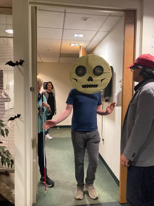 Attendees arriving at the tea gathering. In frame you see a man with a giant skull mask over his face. 