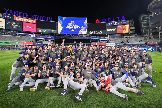 Dodgers players and staff pose for a photo with the World Series trophy. 