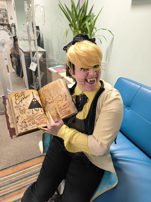 Bill cipher cosplay holding showing off his page in the book. 