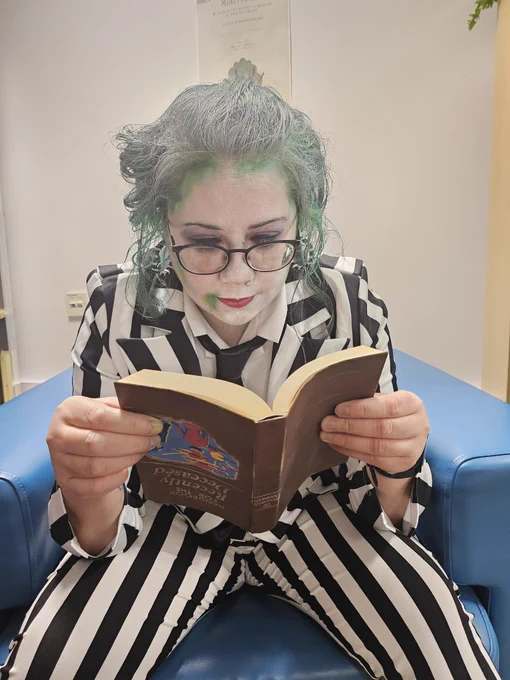 Beetlejuice reading the Book for the Recently Deceased upside down