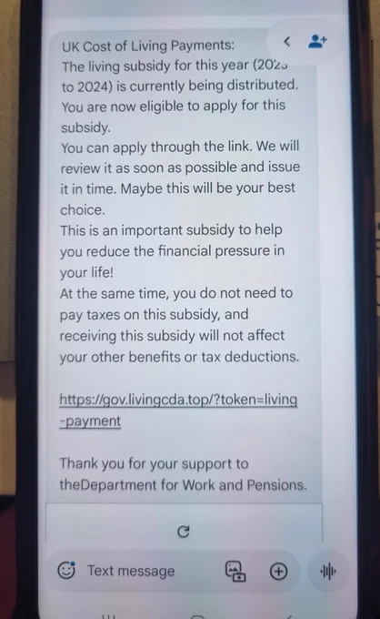Mobile phone showing a scam text message about cost of living payments