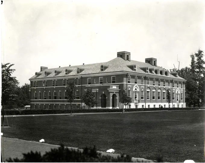  Black and white photo of a four-story, federal-style brick building. 