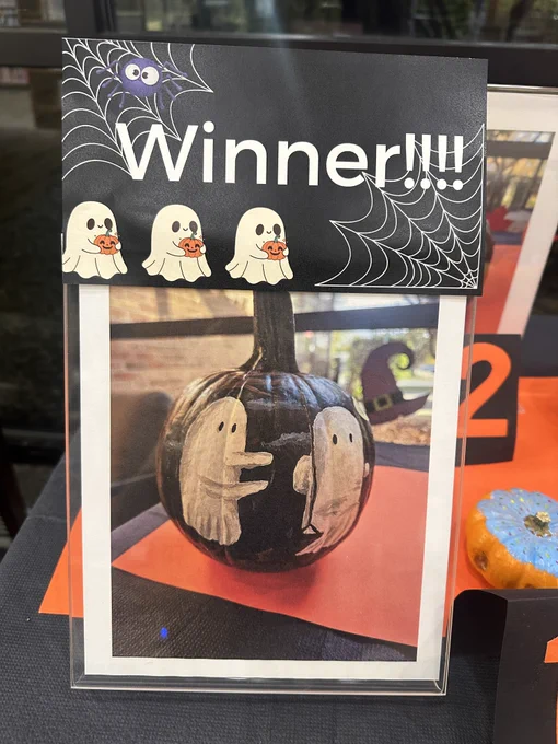 A photo of the winning pumpkin which was painted black with some ghosts on a swing.