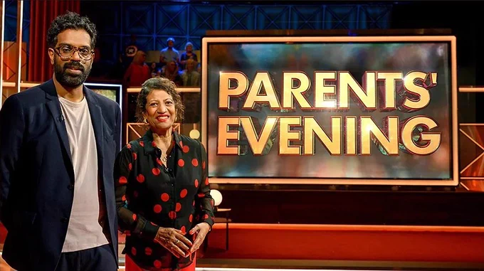 (L-R) Romesh Ranganathan and his mother Shanthi Ranganthan stood next to a screen with the words Parents' Evening