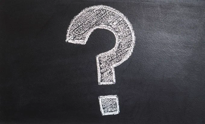 A white question mark drawn in chalk on a blackboard
