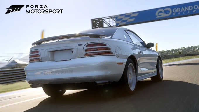 The screenshot shows the 1995 Ford Mustang SVT Cobra R racing at Grand Oak Raceway on a sunny day. The Forza Motorsport logo can be seen in the upper left corner. 