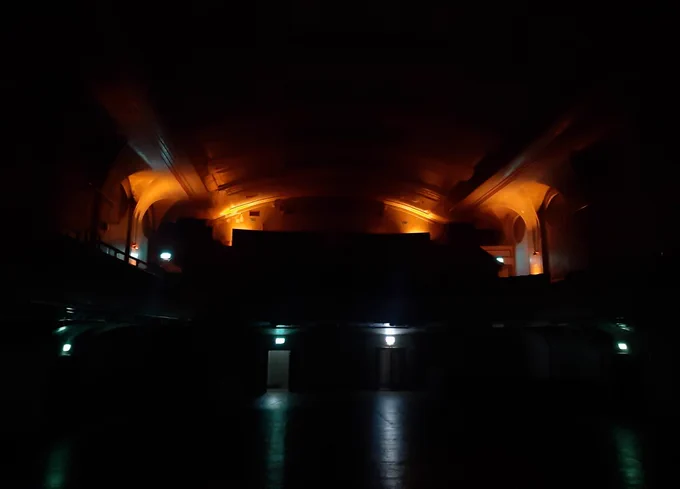 Interior of a theatre in almost complete darkness