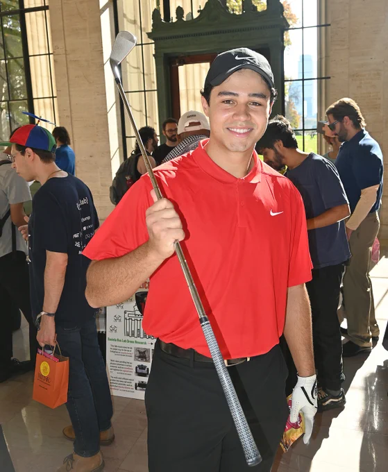 Student dressed as Tiger Woods holding a golf club.