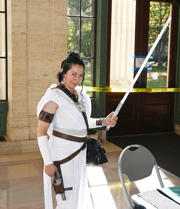 Women dressed as Princess Leia from Star Wars holding a LightSaber.