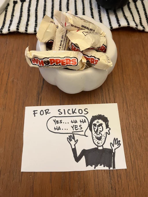 a candy bowl filled with whoppers accompanied by a sign that is the sickos comic