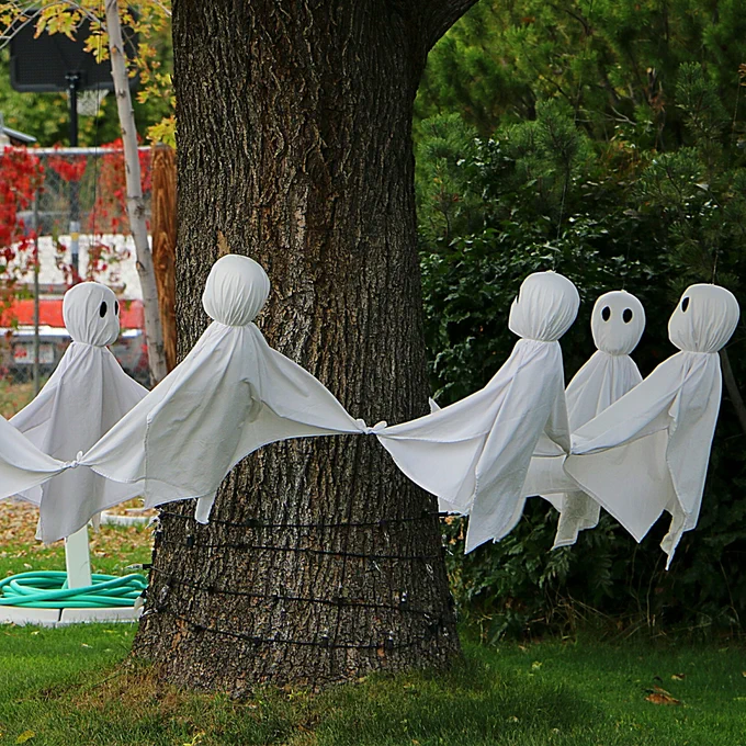 Five fabric ghosts encircle a tree
