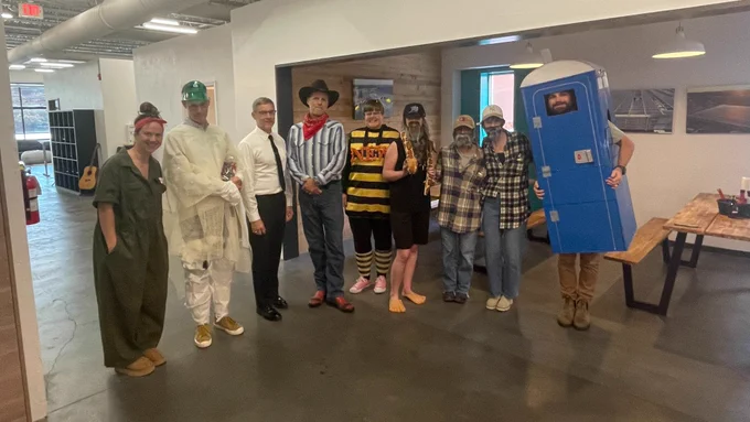 Nine Sun Tribe employees are dressed in Halloween costumes.