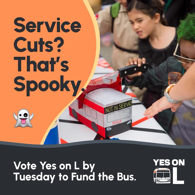 Text "Service Cuts? That's Spooky." Children look at paper bus model with bloody axe in it. "Vote Yes on L by Tuesday to Fund the Bus."